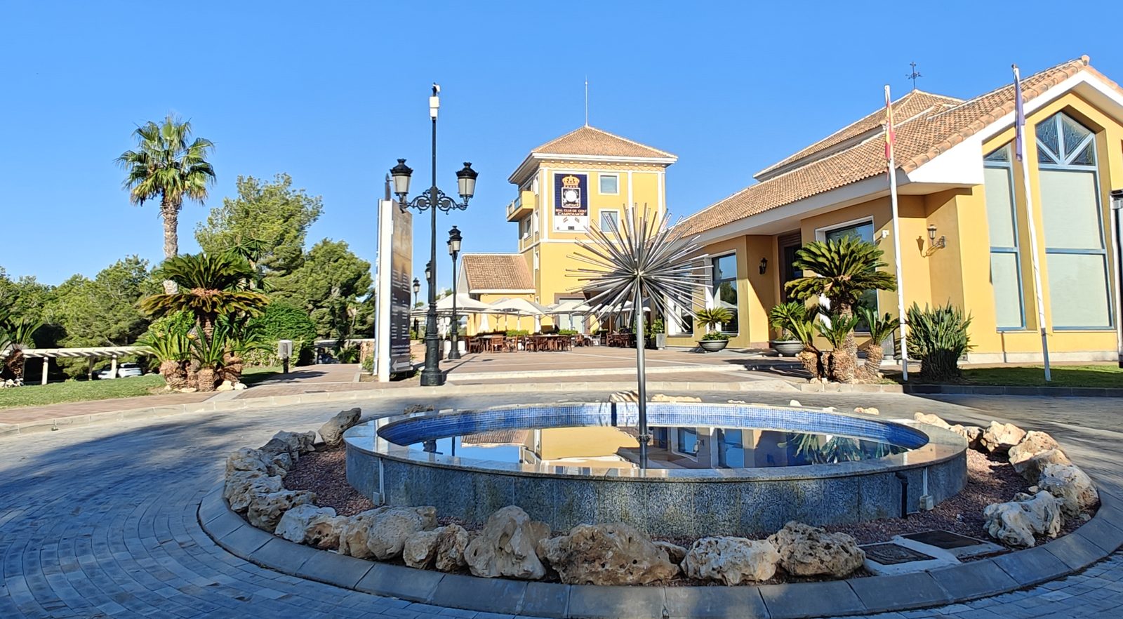 Fontaine devant le club-house jaune du Real Club de Golf Campoamor