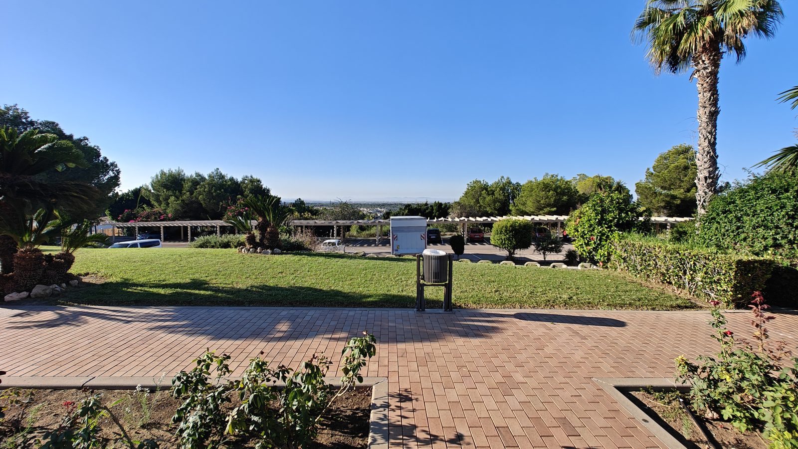 Terrasse pavée, pelouses et massifs au complexe de golf de Campoamor