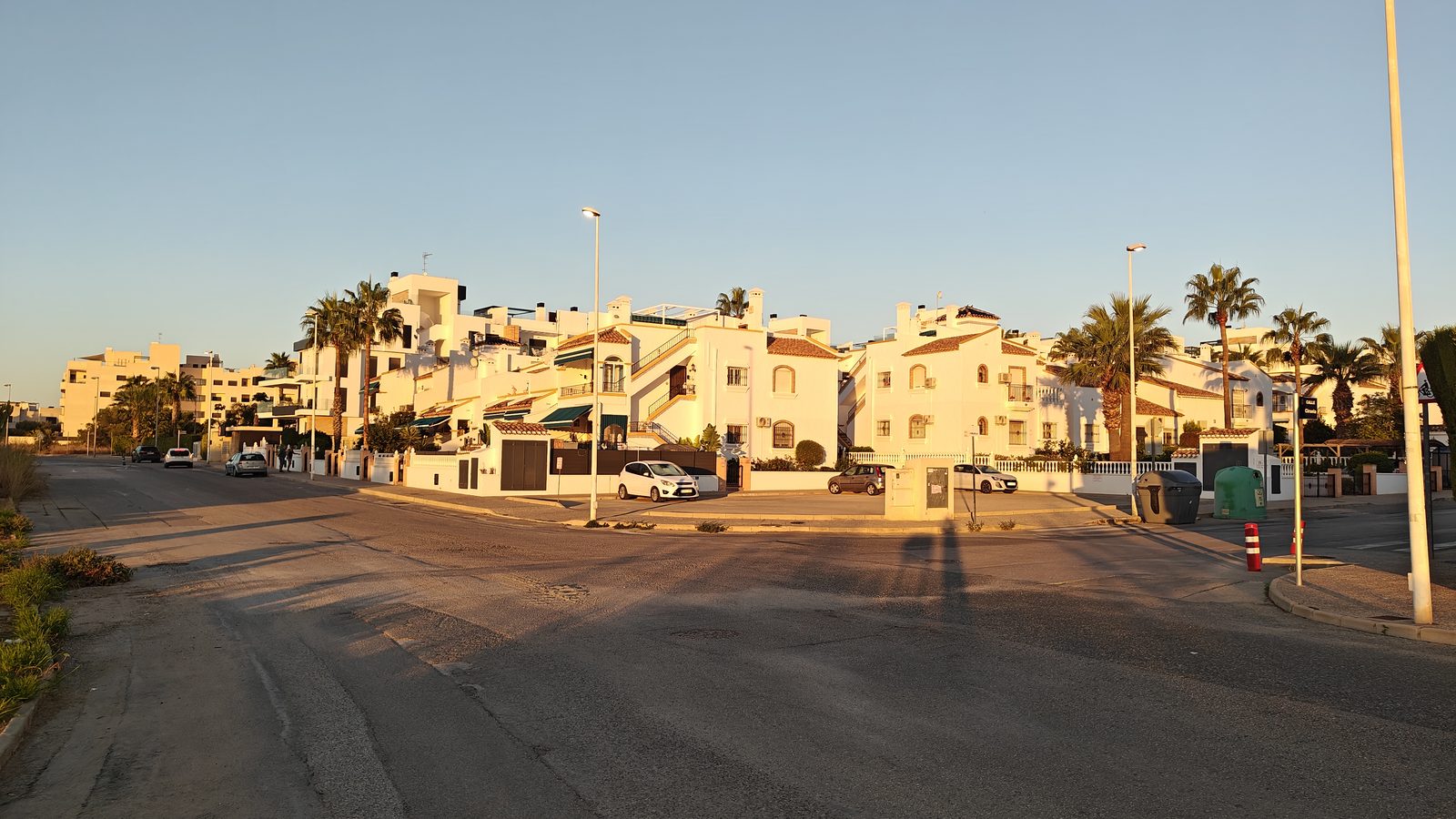 Witte villa's langs een brede avenue in Playa Flamenca in de ochtendzon